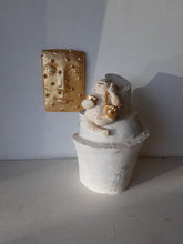 Laughing Buddha sculpture, white ceramic figure with auspicious gold objects on spiral plinth, Buddhist deity