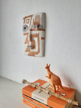 Terracotta orange and white wall sculpture with sawtooth pattern, tribal style decor