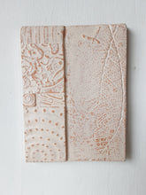 Pair of embossed ceramic wall plaques in pale terracotta and white, pastel textured sculptures