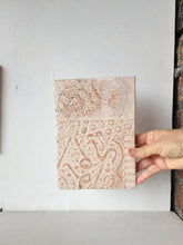 Pair of embossed ceramic wall plaques in pale terracotta and white, pastel textured sculptures