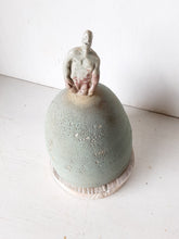 Male statue on mound with timber plinth, ceramic antique look sculpture with celadon green and red glaze