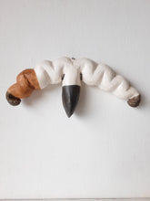 Organic wall sculpture in black white and tan, stylized female reproductive organs in ceramic