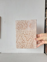 Pair of embossed ceramic wall plaques in pale terracotta and white, pastel textured sculptures