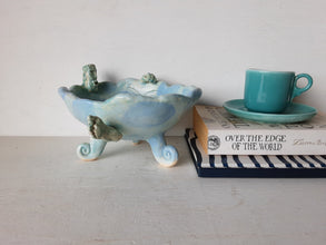 Pale blue bowl with quirky naked male in a spiral water pattern surface, curly footed jewellery organiser dish