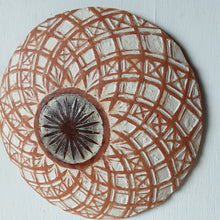 Pair of round white and terracotta ceramic wall plaques with geometric swirling pattern