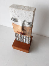 Modern sculpture head on timber plinth, ceramic female face in terracotta with black and white stripes