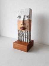 Modern sculpture head on timber plinth, ceramic female face in terracotta with black and white stripes