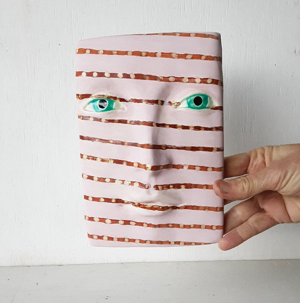 Pink and brown striped wall mask, ceramic sculpture of face