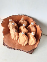 Male nude ceramic sculpture with seven figurines in terracotta on a rust colored curved plinth