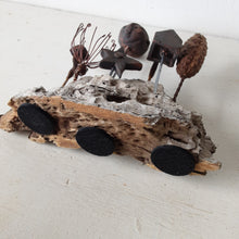 Rustic sculpture with seven recycled and ceramic objects on a timber plinth, coffee table art