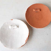 Pair of round white and terracotta ceramic wall plaques with geometric swirling pattern