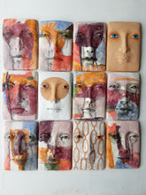 Pink and orange ceramic face sculpture, abstract wall art with multiple colors