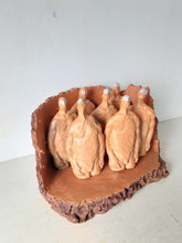 Male nude ceramic sculpture with seven figurines in terracotta on a rust colored curved plinth