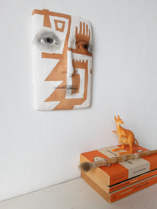 Terracotta orange and white wall sculpture with sawtooth pattern, tribal style decor