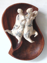 Tattoo wall art of two lovers entwined, sculpture, with reclaimed wood bowl and ceramic figures with butterfly tattoos