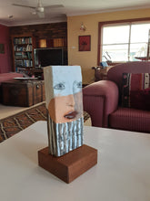 Modern sculpture head on timber plinth, ceramic female face in terracotta with black and white stripes