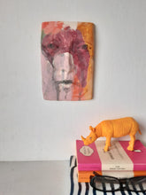 Pink and orange ceramic face sculpture, abstract wall art with multiple colors