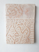 Pair of embossed ceramic wall plaques in pale terracotta and white, pastel textured sculptures