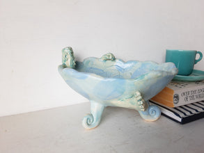 Pale blue bowl with quirky naked male in a spiral water pattern surface, curly footed jewellery organiser dish