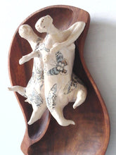 Tattoo wall art of two lovers entwined, sculpture, with reclaimed wood bowl and ceramic figures with butterfly tattoos